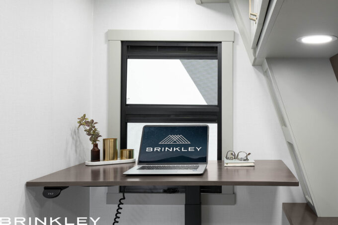 Brinkley RV luxury fifth wheel RV with private dedicated office Space for work and school with electric power standing desk with a laptop set to to be productive.